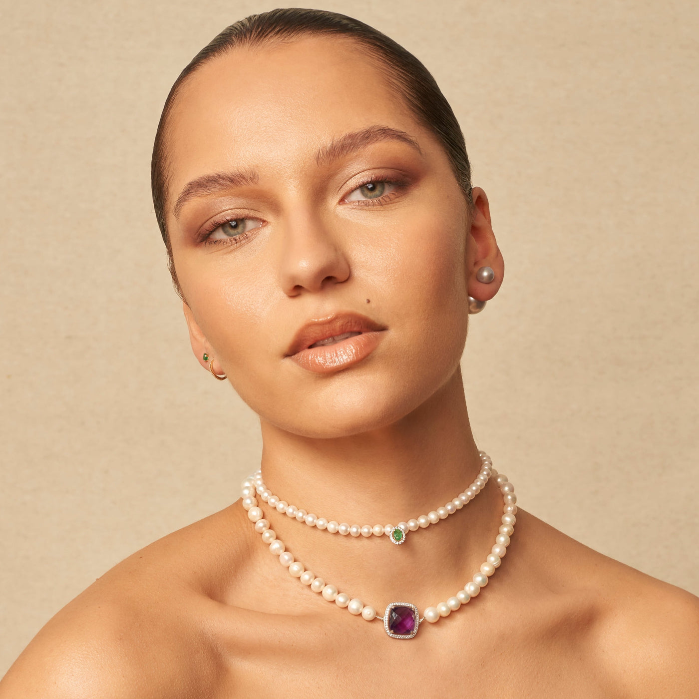 Femme portent des colliersCollier et bague de perla création  en perles avec émeraude et diamants.