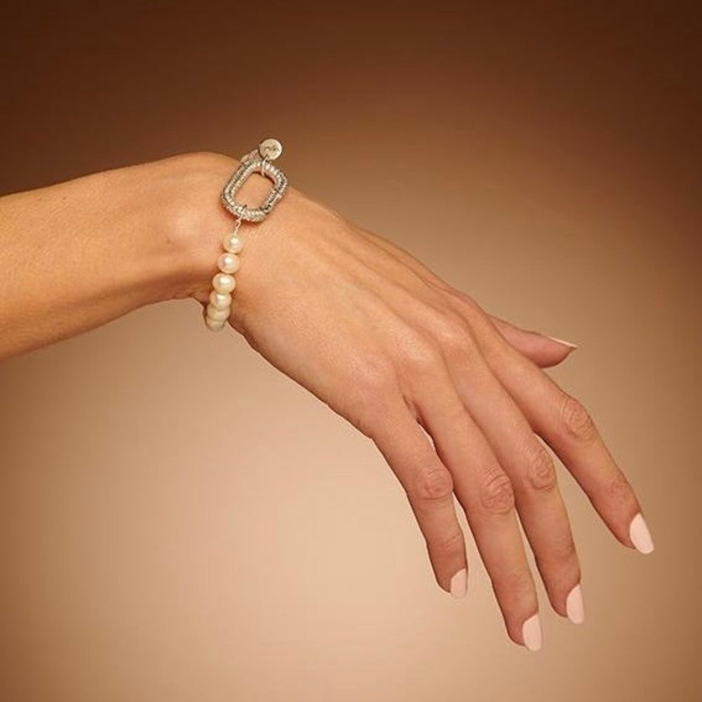 mains portent un bracelet Perla Création.